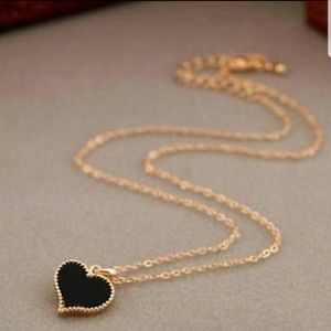 Gold chain necklace with black heart pendant